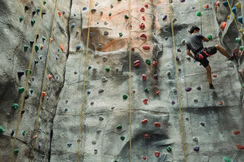Vyras sportiniais drabužiais kabo ant virvės laipiojimo sienelėje – svarbu tinkama priežiūra